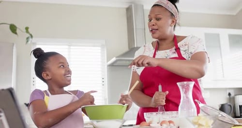Happy Mother and Daughter Baking and Dancing Together