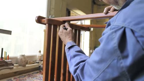 A Carpenter in His Workshop Assembles a Handmade Chair Screws a Bolt Secures It with a Hex Key