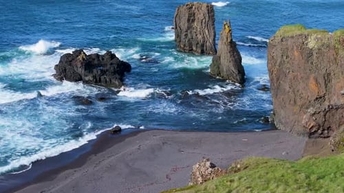 Aerial view of rugged cliffs and ocean waves, Iceland.