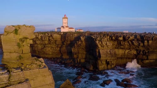 Dramatic Lighthouse on Cliffside at Sunrise or Sunset