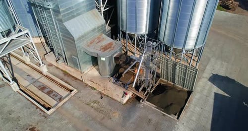 Moderner Getreideaufzug aus Metall auf dem Feld. Getreidespeicher für die Lagerung und Verarbeitung landwirtschaftlicher Nutzpflanzen.
