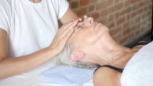 Senior Woman Relaxing With Facial Massage Treatment