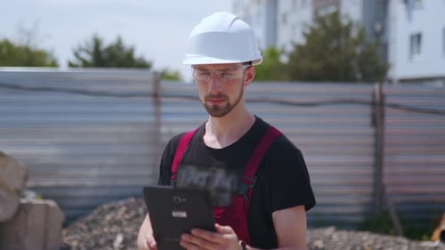 Close Up Shot Shot of Professional Construction Worker Wearing Hard Hat and Safety Glasses Holds