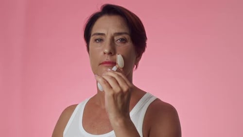 Gen X Woman Massaging Face with Jade Roller