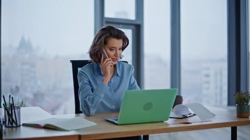 Woman Talking on Phone at Desk in Office