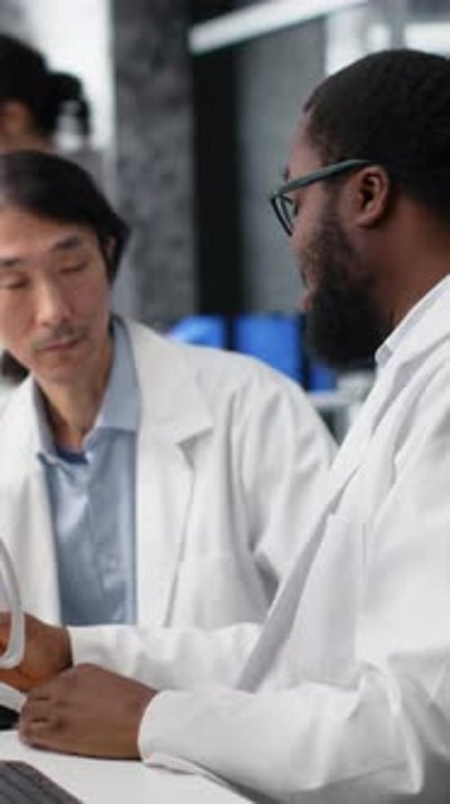 Colegas de laboratório de diagnóstico de vídeo vertical usando microscópio