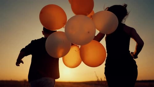 Mother and Child Run with Balloons at Sunset