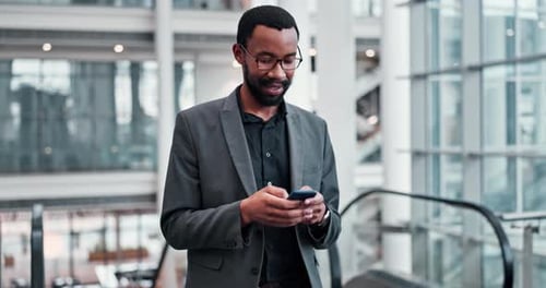 Young Adult Using Mobile Phone in Modern Atrium