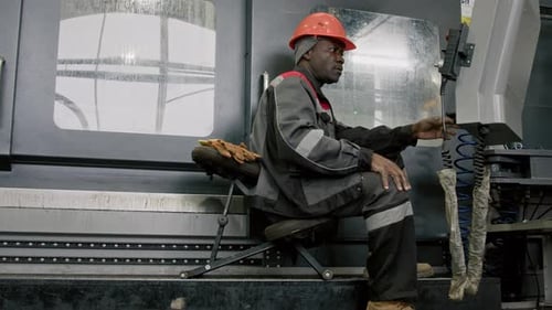 Workman Operating Industrial Controller at Manufacturing Factory