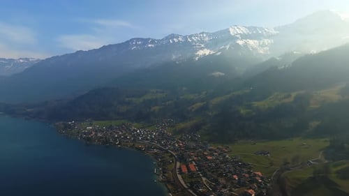 Aerial View of the Snow Rocky Cliffs with Forest By the Lake