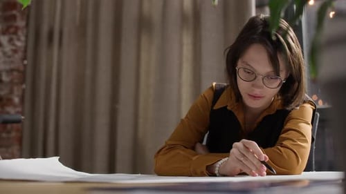 Junge Architektin arbeitet am Schreibtisch an einem Entwurf