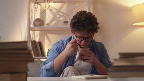 Young Adult Eats Noodles Indoors