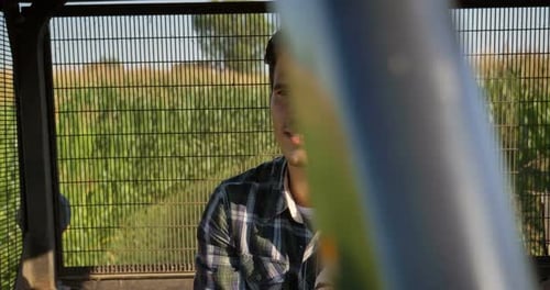 Portrait of a beautiful young farmer (student), sits inside in the tractor cabin, rides the field,
