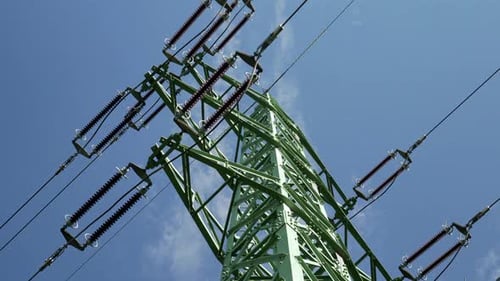 Hochspannungsleitungen und Pylon, Niederwinkelaufnahme mit blauem Himmel im Hintergrund - nach rechts gleitend