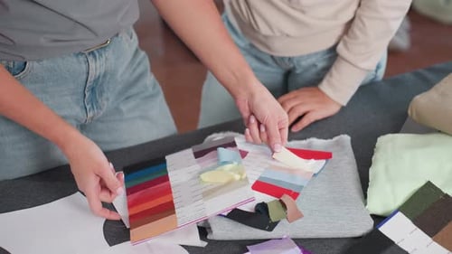 Fabric Designers Selecting Colors From Vibrant Color Panel at Creative Studio