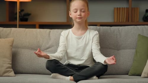Child Meditating on Sofa Indoors