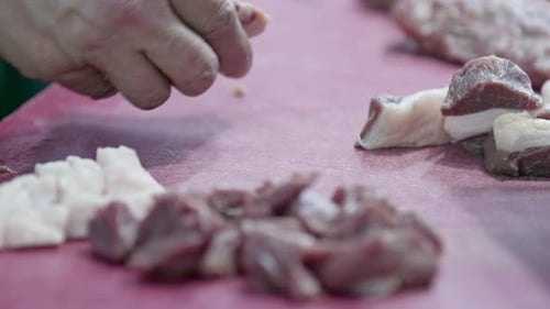 Butcher Cuts Meat In His Shop