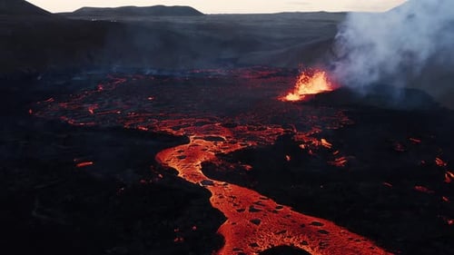 Lava river flowing away from explosive erupting fissure volcano in Iceland, natural phenomenon