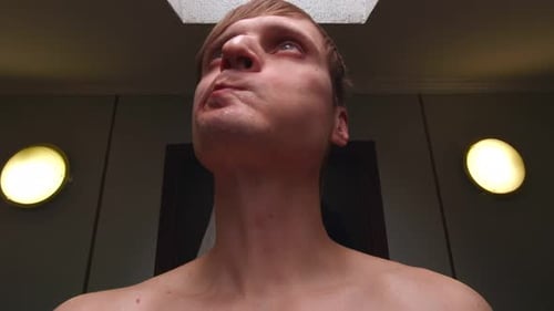 Man Tilting Head Up in Indoor Setting