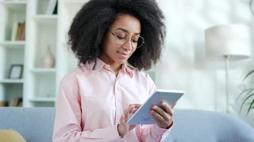 Woman Using Tablet on Couch at Home