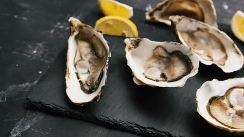 Delicious Oysters on Serving Board with Lemon Wedges