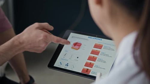 Dermatologist Presenting Melanoma Information on Digital Tablet Screen