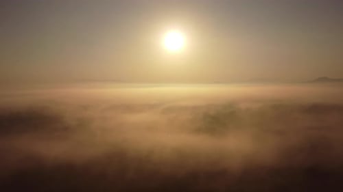 Aerial view of sky and sunlight during beautiful sunrise with clouds and fog in the morning.