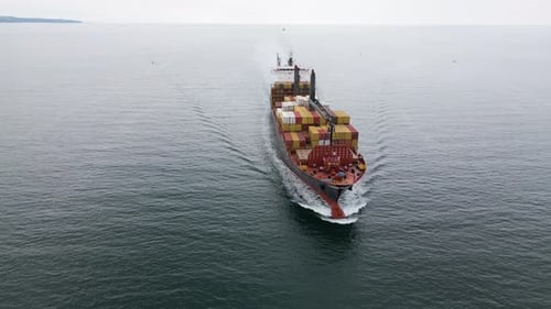 Aerial View of a Large Cargo Ship Carrying Colorful Containers Approaching the Port Maritime