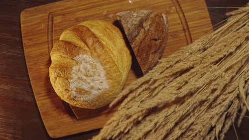 Artisan Bread and Wheat on Wooden Board