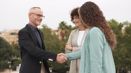 Happy Business Partners Shaking Hands in City