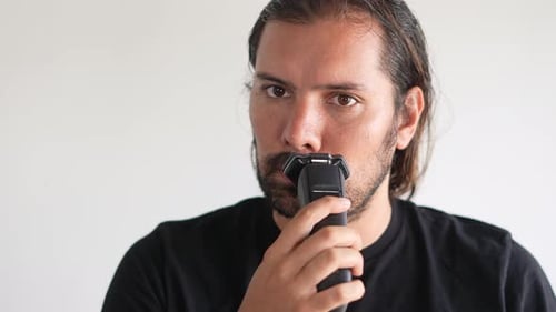 Man Trims Mustache with Electric Trimmer, Close Up
