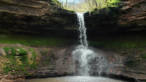 Drone view of cascade waterfall in Saharna Monastery, Moldova. Forest and cave. Slow motion