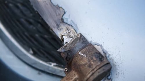 Car Body Shop Repair Man Processes the Welding Seam Using an Angle Grinder on Replaced Car Part