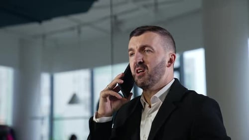 Man in Suit Talking on Cell Phone in Office