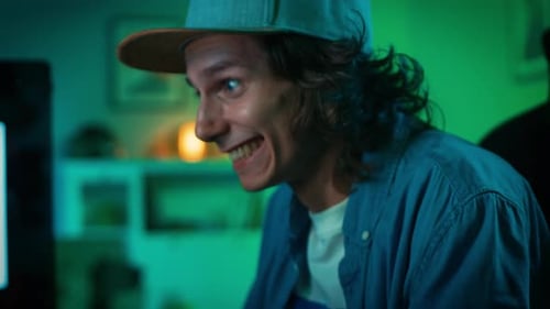 Close Up of an Excited Gamer Playing Online Shooter Video Game on His Personal Computer. Room and P