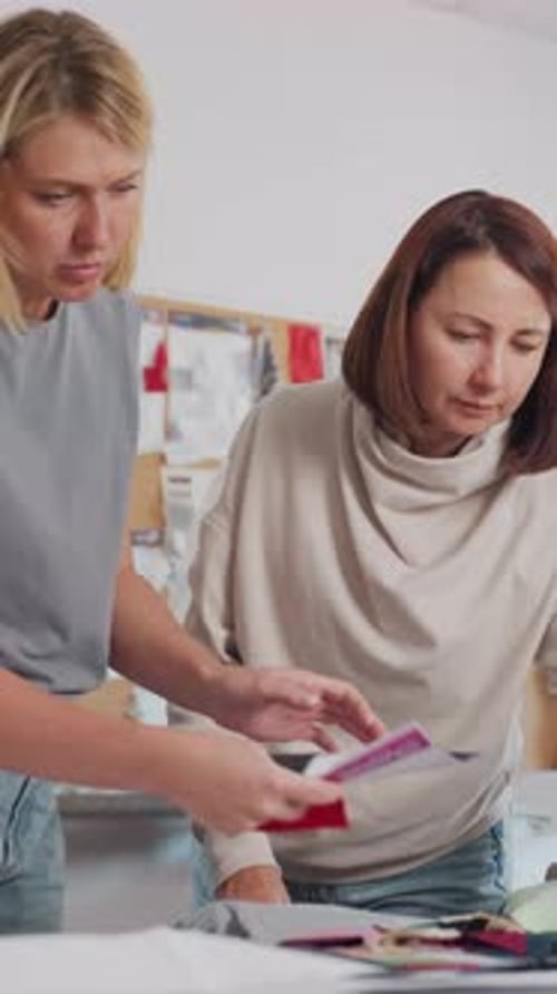 Caucasian Women Matching Color Palette and Swatches on Table in Bright Studio Designers Test