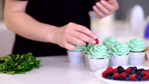 Dessert Cook Female Hand Decorates Tasty Cupcakes Turquoise Cream Topping with Raspberries and