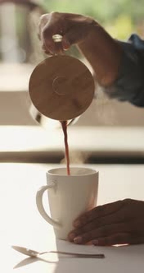 Pouring Steaming Coffee into White Mug in Kitchen