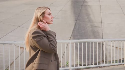 Stylish Blonde Business Woman in Long Coat Walking in City on Autumn Day