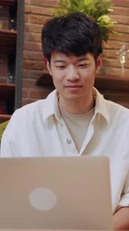 A Young Adult Engaged in Working on Their Laptop in a Cozy and Comfortable Environment