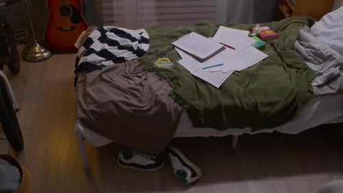 School Papers on Messy Bed in Empty Teenage Bedroom