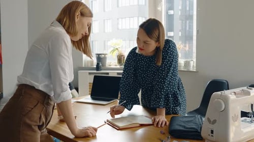 Fashion Designers Collaborating on Design in Workplace