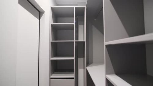 Elegante estantería gris del suelo al techo. Muchos estantes. Muebles en un pequeño vestidor