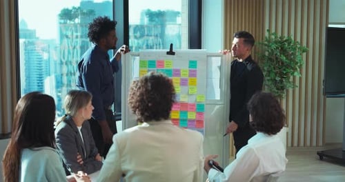 Team Discussing Project With Colorful Sticky Notes