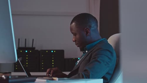 Man Works on Computer in Dark, Modern Office