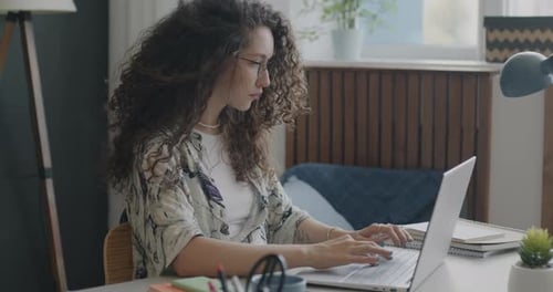 Woman Working On Laptop At Home Office Desk