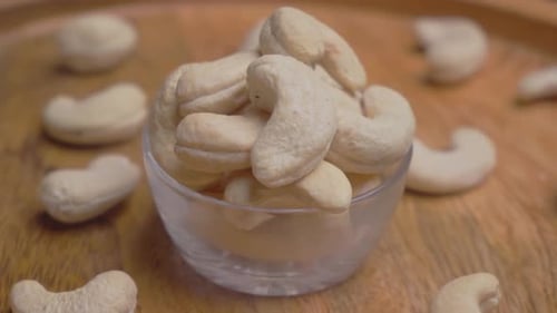 Bowl of Raw Cashews on Wooden Tray