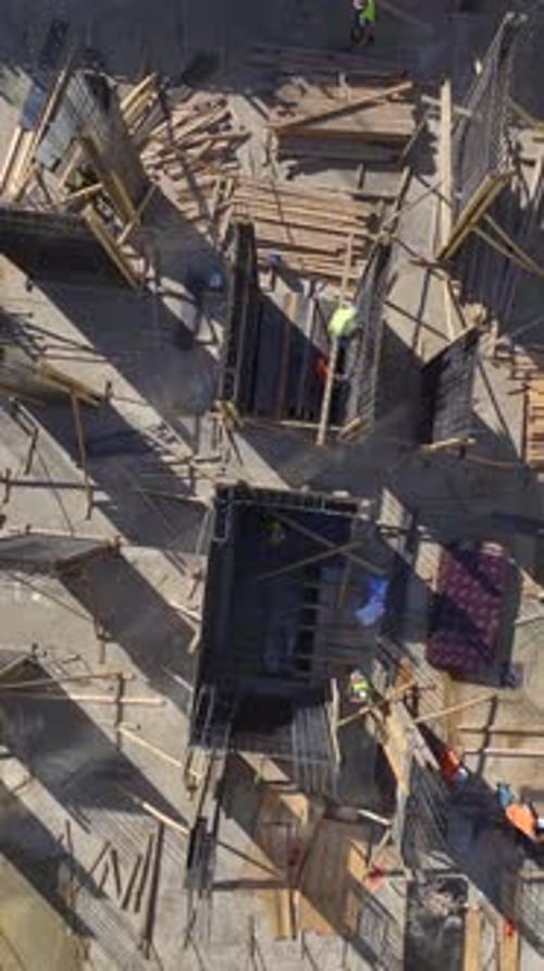 Vertical Video Busy Construction Scene with Workers Focused on Building Walls and Advancing the