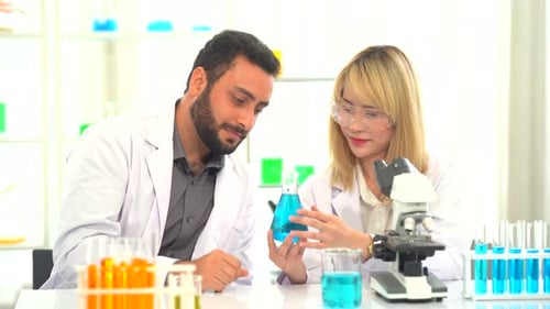 Focused, serious medical scientists analyzing research scans on a computer, working late in the lab