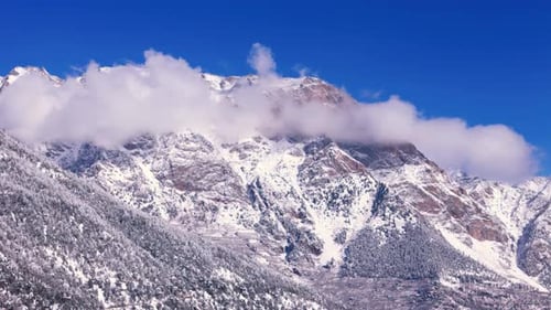 aerial view of majestic snow-capped mountains under a bright blue sky